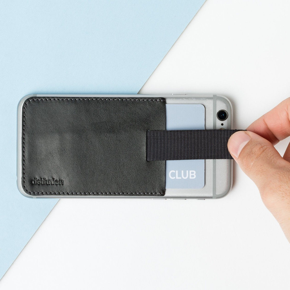 black leather wally junior stick-on attached to an iphone with hand using pull-tab to withdraw cards